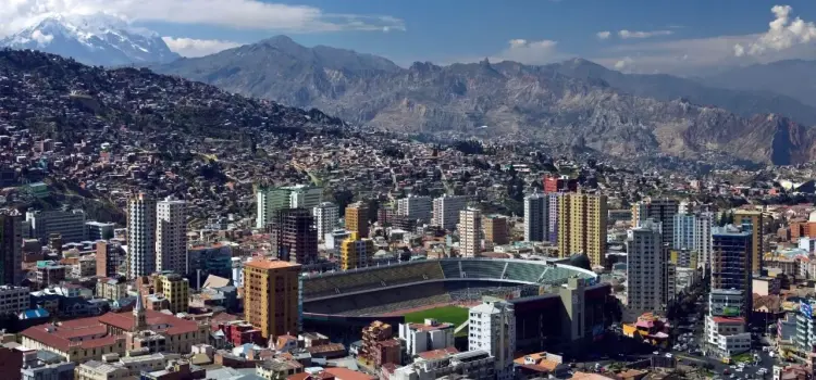 Panoramic view of La Paz Bolivia cityscape with modern stadium surrounded by Andes mountains