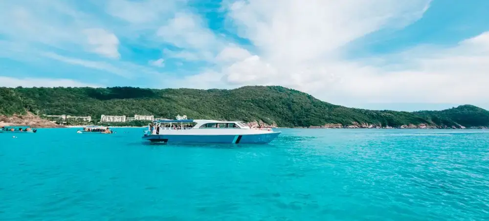 Luxury yacht cruising turquoise waters near Langkawi's lush tropical coastline and pristine beaches