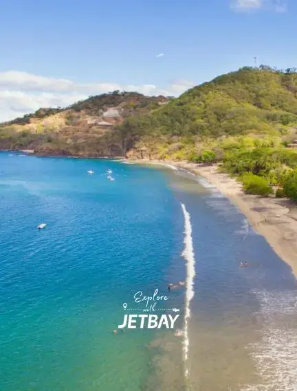 Pristine Costa Rican beach with turquoise waters and lush green hills showcasing Liberia's tropical coastline