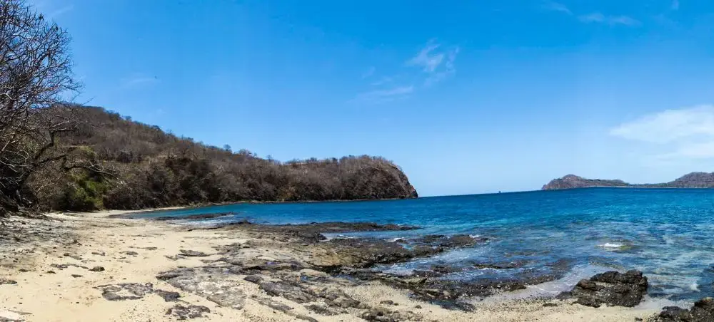 Pristine Costa Rican coastline with turquoise waters and forested hills near Liberia's luxury beaches