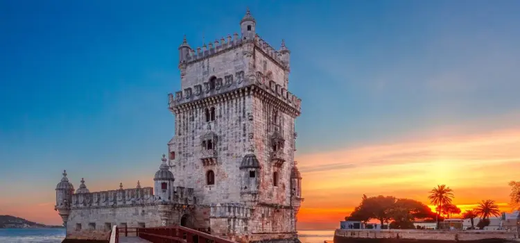Historic Belém Tower fortress illuminated by golden sunset over Tagus River in Lisbon, Portugal