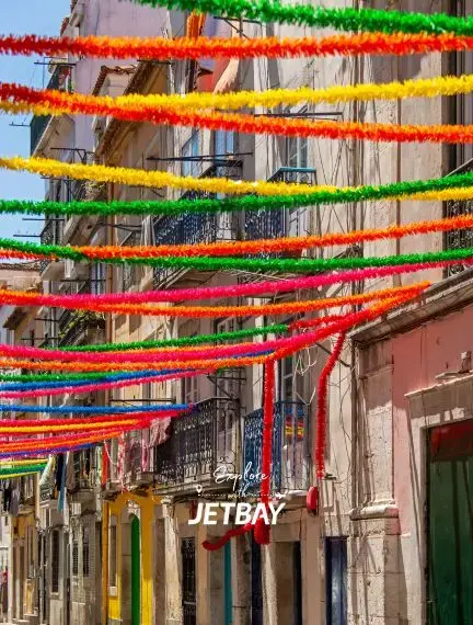 Colorful festival streamers decorating historic Lisbon street with traditional Portuguese architecture