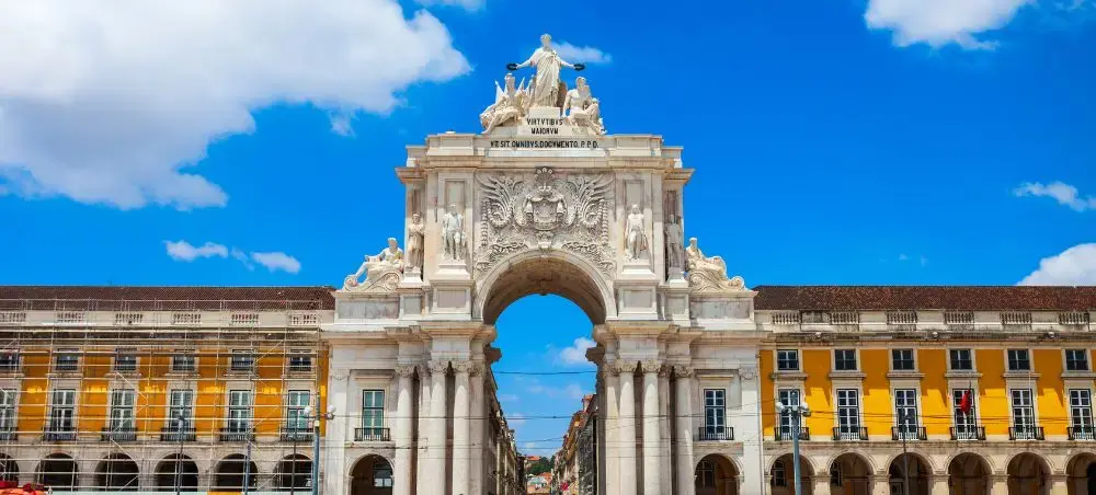 Ornate Rua Augusta Arch with classical sculptures stands majestically in Lisbon's Commerce Square
