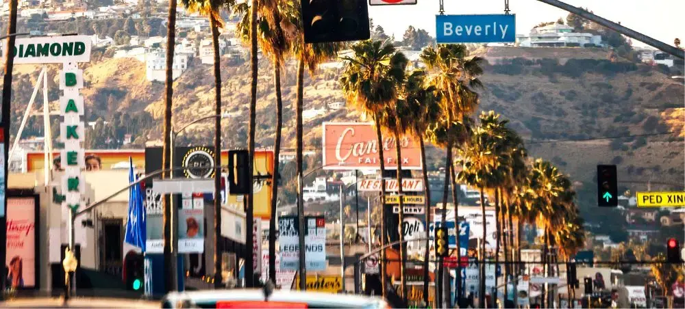 Iconic Sunset Strip in West Hollywood showcasing palm trees, neon signs, and Beverly Hills proximity