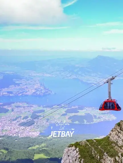 Red cable car gondola ascending Mount Pilatus with panoramic views of Lake Lucerne and Swiss Alps below