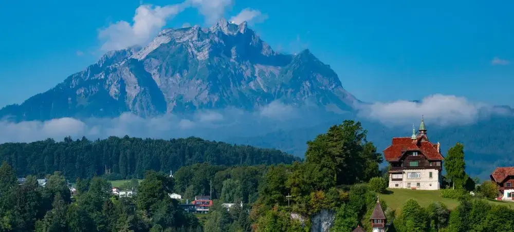 Majestic Mount Pilatus towers over Lucerne's charming lakeside villas and traditional Swiss architecture