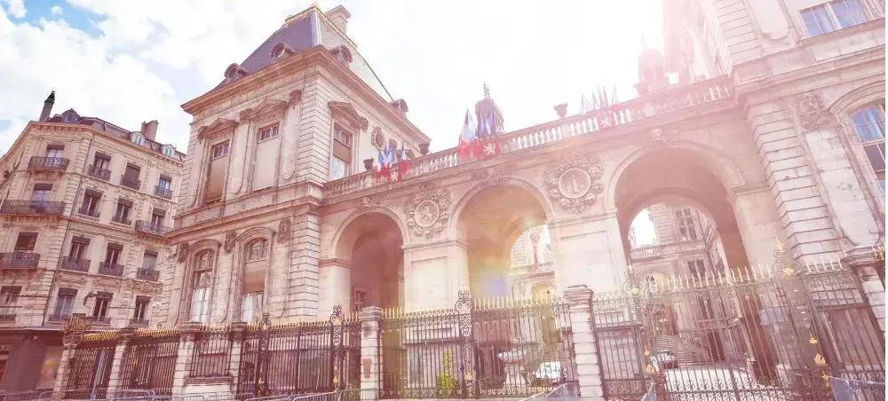 Historic Lyon city hall with ornate French architecture and golden sunlight illuminating classical facades