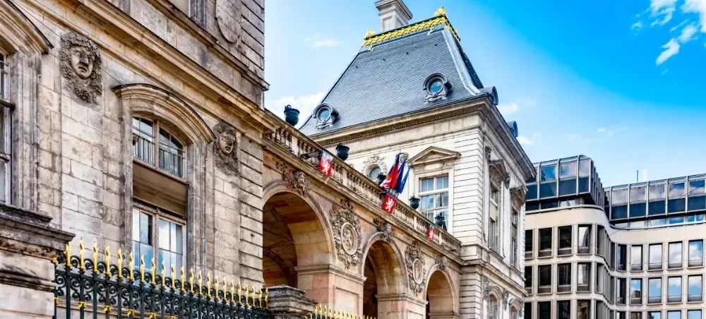 Historic Lyon city hall with ornate French architecture and flags displayed on elegant stone facade