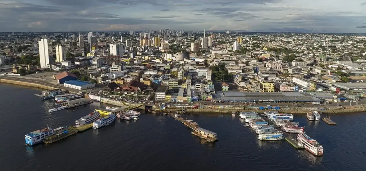 Aerial view of Manaus waterfront showing bustling port with boats and urban skyline in Amazon region