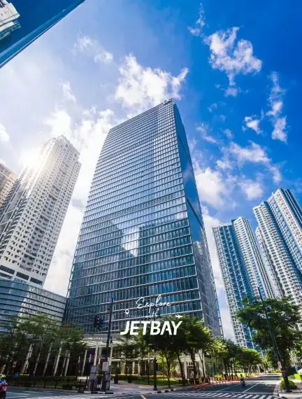 Modern glass skyscrapers and Jetbay office building in Manila's business district under bright blue sky