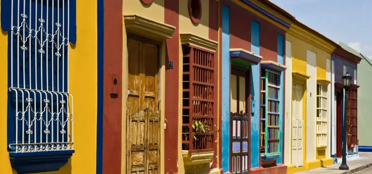 Vibrant colonial houses with colorful facades and ornate balconies line a historic street in Maracaibo, Venezuela