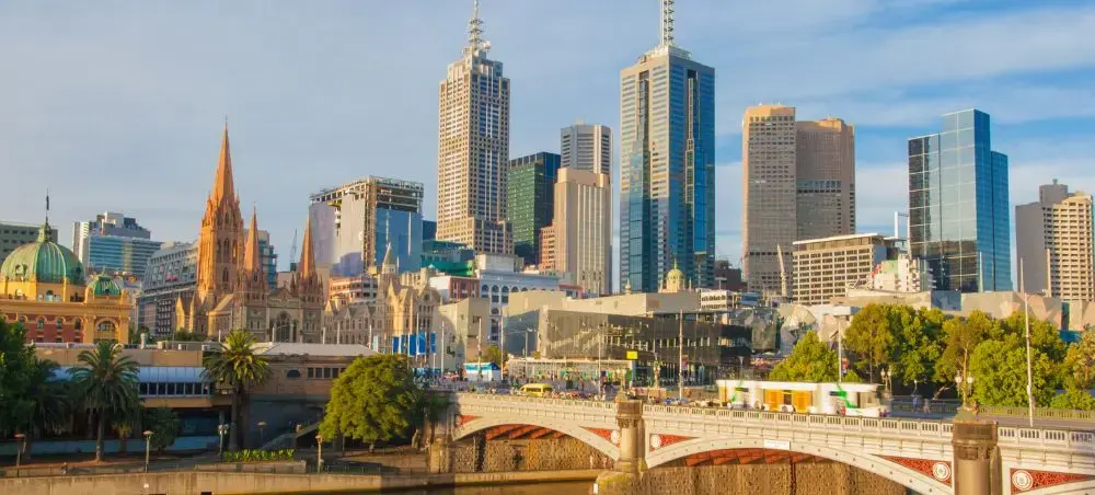 Melbourne's iconic skyline featuring modern skyscrapers and historic cathedral spires across the Yarra River