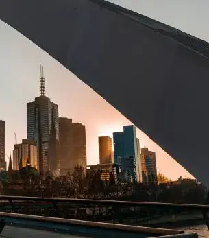 Melbourne skyline at sunset viewed through modern architectural frame showcasing Australia's cultural capital
