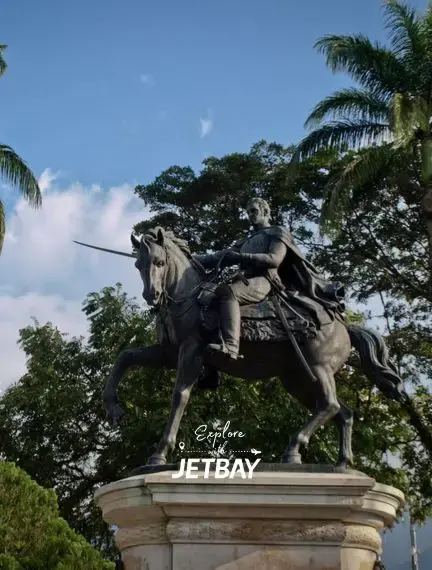 Historic equestrian statue in Merida Venezuela surrounded by tropical palm trees and lush greenery