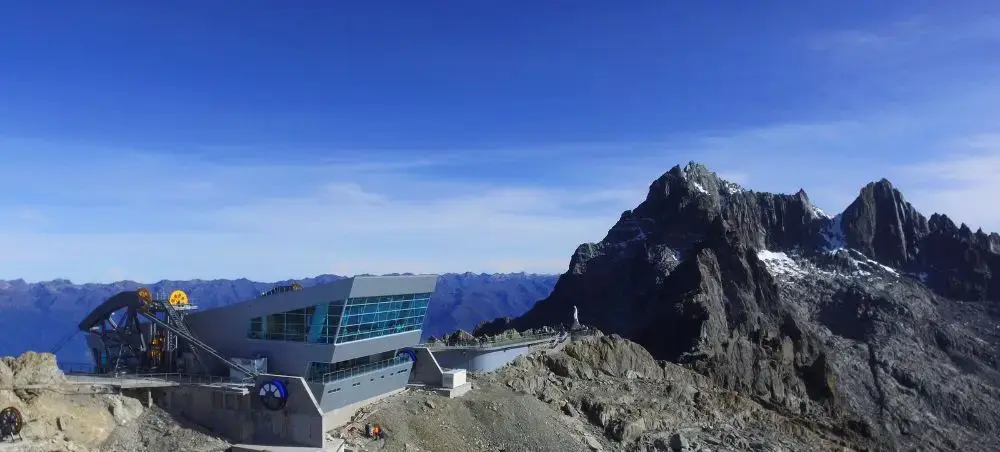 Modern mountain cable car station with dramatic snow-capped peaks and alpine landscape in Merida
