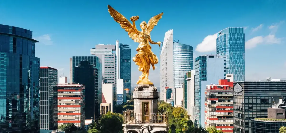 Golden Angel of Independence monument towering over Mexico City's modern skyline and business district