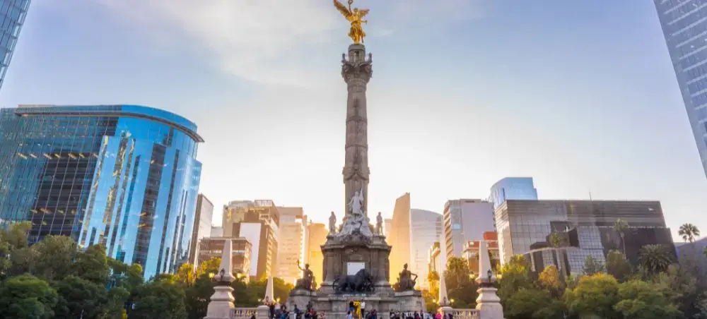 Angel of Independence monument surrounded by modern skyscrapers in Mexico City's financial district