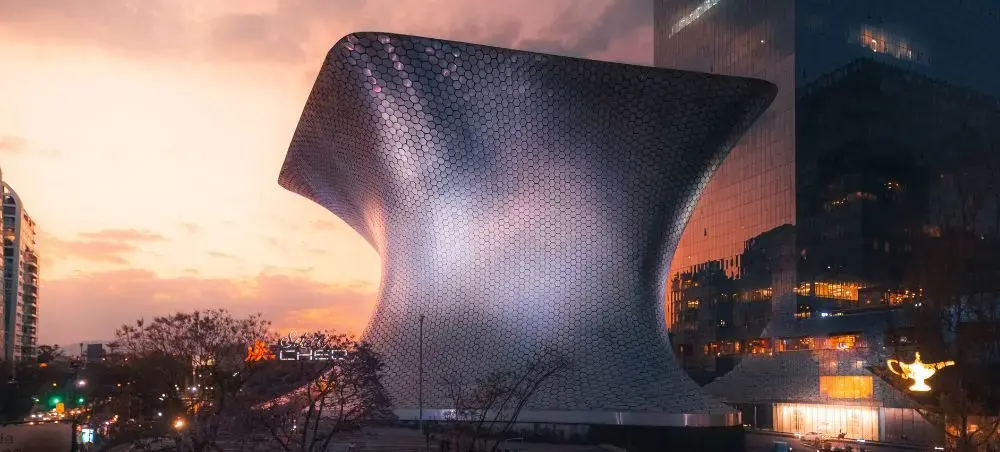 Modern architectural marvel in Mexico City showcasing contemporary design against vibrant sunset skyline