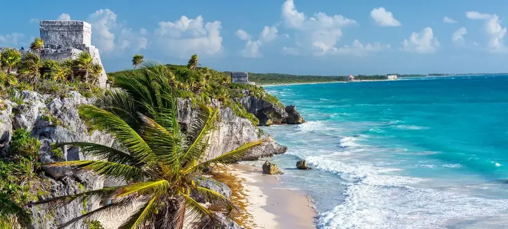 Ancient Mayan ruins overlooking turquoise Caribbean waters and pristine beach in Mexico's Riviera Maya