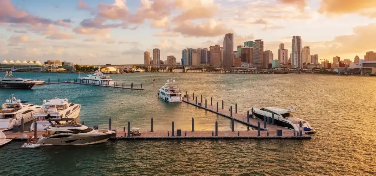 Miami skyline at golden hour with luxury yachts docked at waterfront marina showcasing premium travel destination