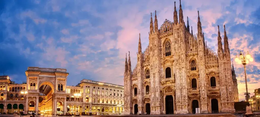 Milan's iconic Gothic Duomo cathedral and historic Galleria Vittorio Emanuele II illuminated at sunset