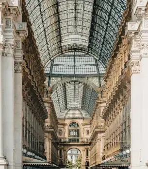 Elegant glass-vaulted Galleria Vittorio Emanuele II arcade in Milan showcasing luxury shopping destination
