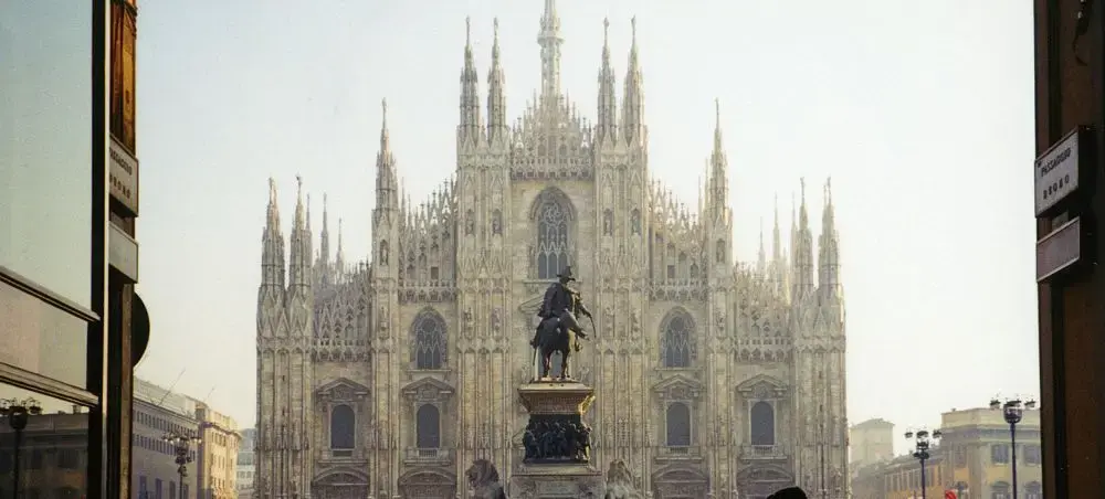 Milan's iconic Gothic cathedral Duomo dominates the historic city center with ornate spires and statue