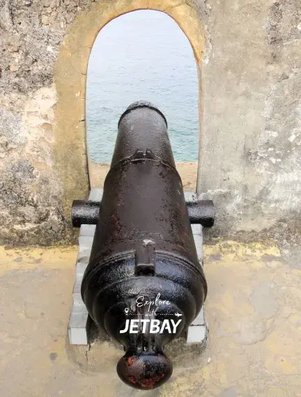 Historic cannon overlooking turquoise waters at Fort Jesus in Mombasa, showcasing Kenya's coastal heritage