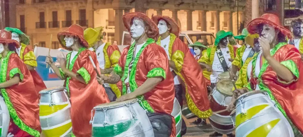 Colorful carnival drummers in traditional costumes performing during Montevideo's vibrant street festival