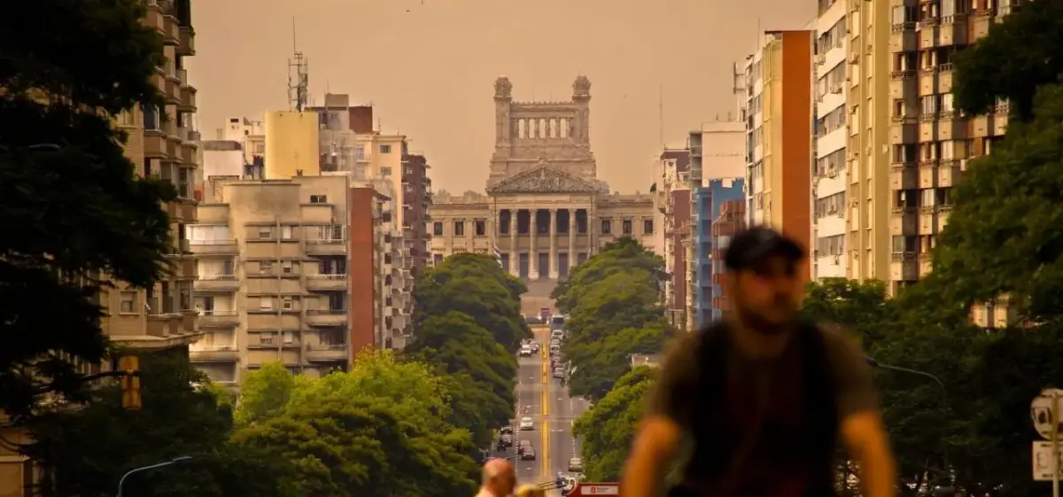 Montevideo's historic Legislative Palace framed by tree-lined avenue and modern buildings at golden hour