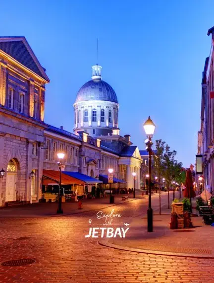 Historic cobblestone streets and illuminated dome of Bonsecours Market in Old Montreal at twilight