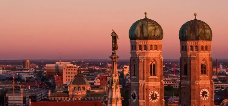 Munich's iconic twin-towered Frauenkirche cathedral dominates the city skyline at golden hour sunset