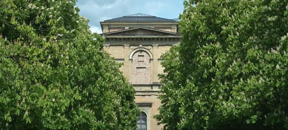 Historic Bavarian architecture framed by lush green trees in Munich's cultural district