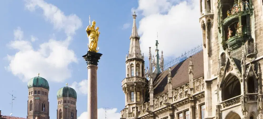 Munich's iconic Marienplatz showcasing Gothic architecture with golden Mariensäule column and twin cathedral towers