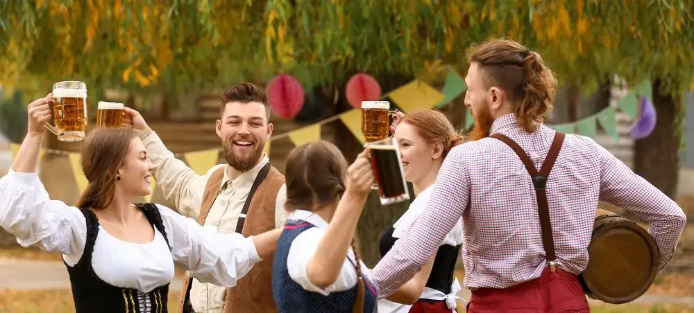 Friends in traditional Bavarian attire toasting with beer steins at Munich's famous Oktoberfest celebration