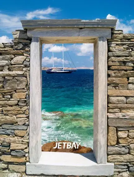 Ancient stone doorway frames turquoise Aegean waters and luxury yacht in Mykonos Greece destination