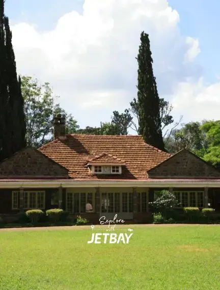 Elegant colonial-style mansion with terracotta roof tiles surrounded by manicured gardens in Nairobi