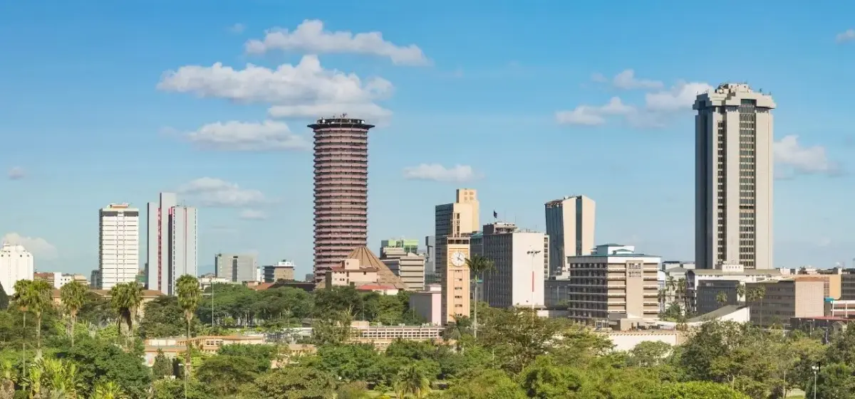 Nairobi skyline showcasing modern high-rise buildings and lush green spaces under bright blue skies