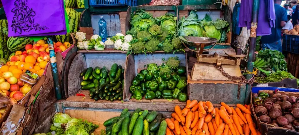 Vibrant local market stall in Nakuru displaying fresh vegetables including carrots, peppers, and leafy greens