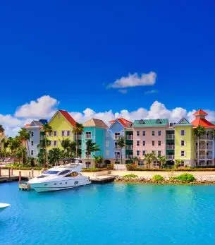 Colorful waterfront buildings and luxury yacht in Nassau harbor showcase Bahamas destination charm