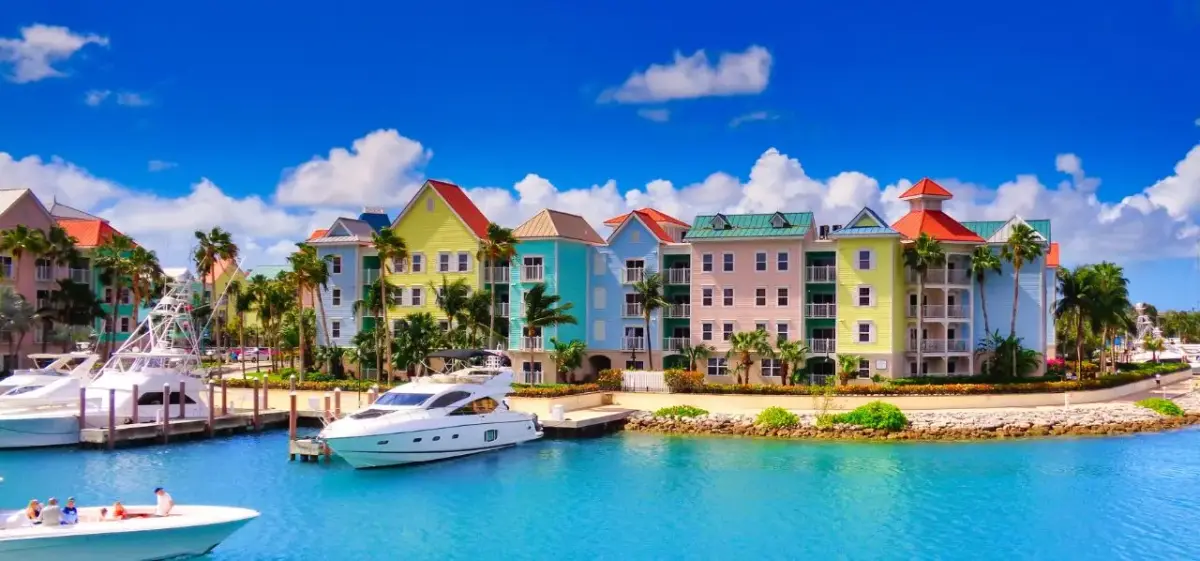 Vibrant waterfront resort buildings in Nassau Bahamas with luxury yachts moored in crystal-clear turquoise waters