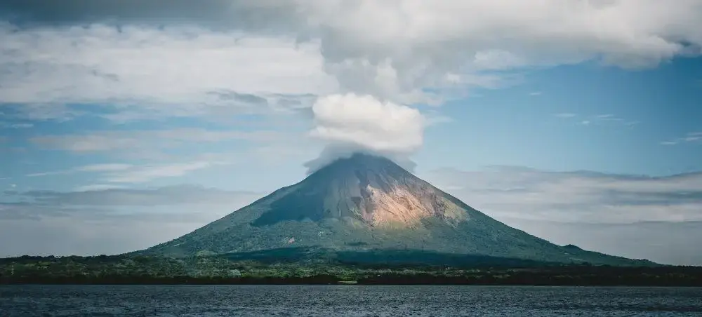 Majestic Concepción volcano rising from Lake Nicaragua with lush tropical forests and dramatic clouds