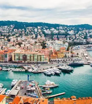 Aerial view of Nice's colorful waterfront with luxury yachts moored in the Mediterranean harbor