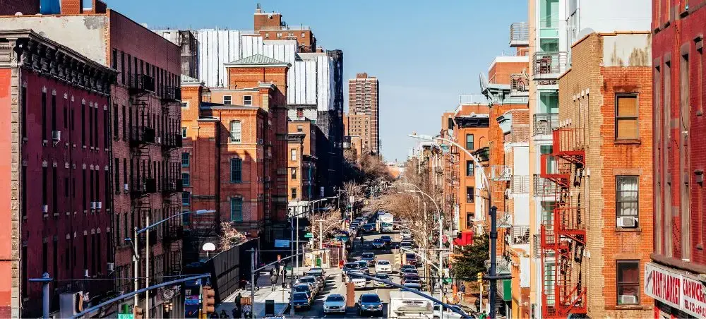 Bustling Manhattan street lined with historic brick buildings and modern traffic in New York City