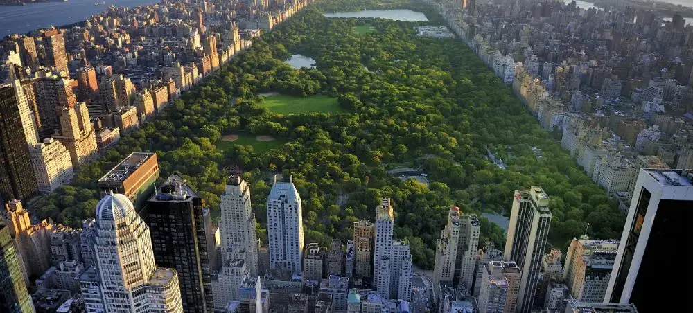 Aerial view of Central Park surrounded by Manhattan skyscrapers showcasing NYC's luxury travel destination
