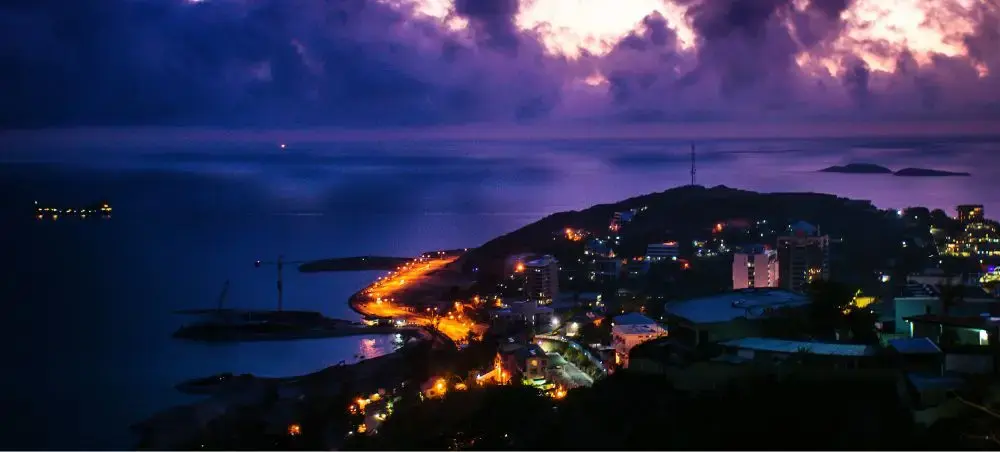 Coastal Papua New Guinea town illuminated at twilight with harbor lights reflecting on calm waters