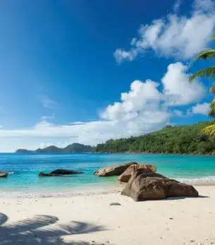Pristine white sand beach with turquoise waters and granite boulders in Paradise Island, Bahamas
