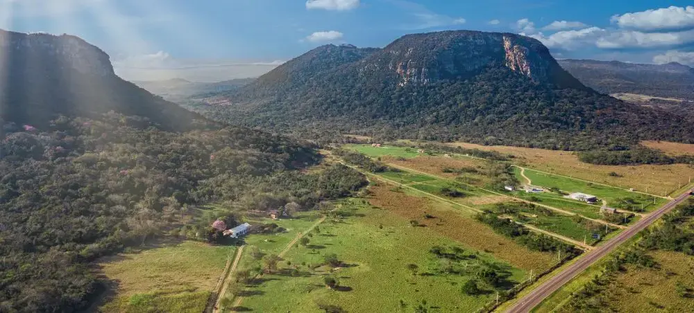 Aerial view of Paraguay's lush countryside with rolling hills, green farmland, and winding roads through rural valleys