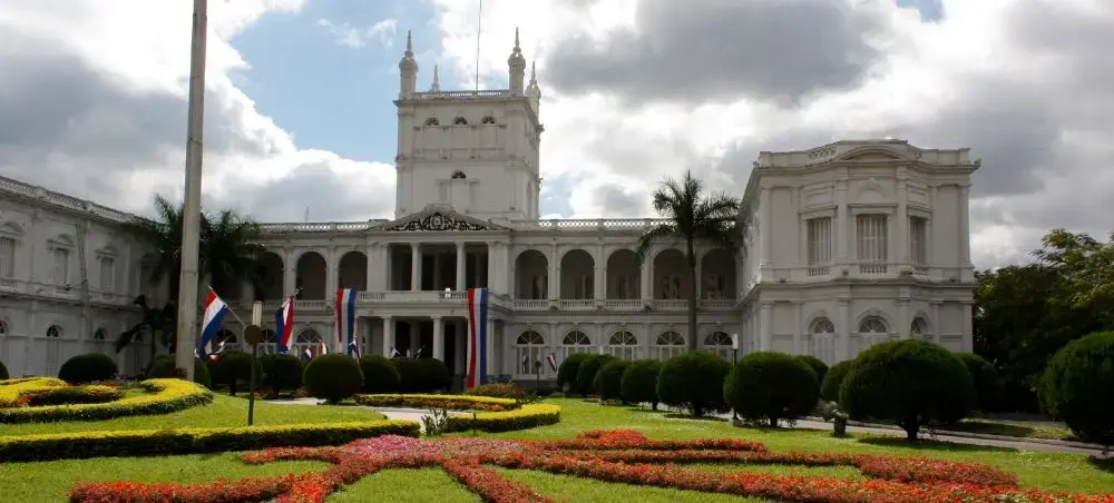 Presidential Palace in Asunción with ornate gardens and Paraguayan flags showcasing the capital's grandeur