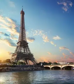 Eiffel Tower at sunset with Seine River and bridge creating romantic Paris skyline for luxury travel
